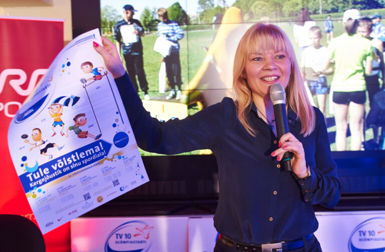 Anu Säärits kutsub koolinoori võistlema. Foto on tehtud „TV 10 olümpiastardi” 45. hooaja avaüritusel. Foto: Siim Lõvi / ERR
